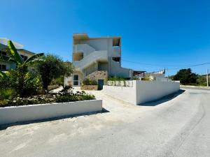 a building on a street next to a road at Peter's Place Studios & Suites in Faliraki