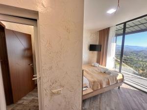 a bedroom with a bed and a large window at Green Cape Tower in Batumi