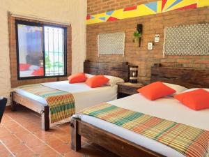 a bedroom with two beds and a brick wall at Mamatina Hotel in Santa Rosa de Cabal