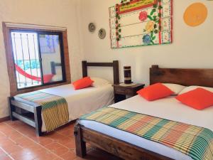 een slaapkamer met 2 bedden en een raam bij Mamatina Hotel in Santa Rosa de Cabal