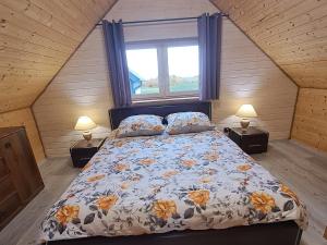 ein Schlafzimmer mit einem Bett, einem Fenster und zwei Lampen in der Unterkunft Jaśkowe Wzgórze domki na wynajem Szymbark, balia, Domek nr 2 i 3 in Szymbark