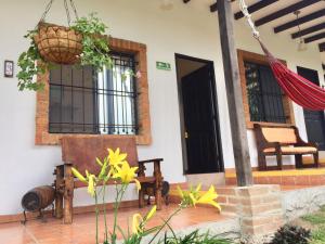 - une terrasse couverte à l'avant d'une maison avec un hamac dans l'établissement Mamatina Hotel, à Santa Rosa de Cabal