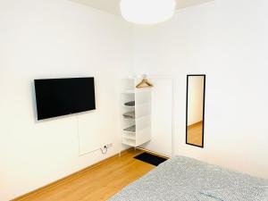 ein Wohnzimmer mit einem TV an der Wand in der Unterkunft VIKTORIA RESIDENCE in Saarbrücken