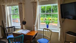 a dining room with a table and chairs and a window at Mandalay Holiday Home in Amesbury
