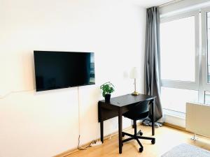 Zimmer mit einem Schreibtisch und einem TV an der Wand in der Unterkunft VIKTORIA RESIDENCE in Saarbrücken