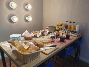 einen Tisch mit Brotkörben und Körben mit Lebensmitteln in der Unterkunft Best Western Hotel Kobalt in Épagny