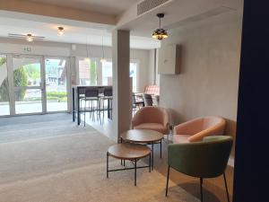 ein Wohnzimmer mit Stühlen, einem Tisch und einer Theke in der Unterkunft Best Western Hotel Kobalt in Épagny