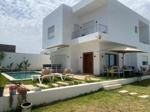 a villa with a swimming pool and a house at Dar Selima by Amin BenSassi in Hammamet