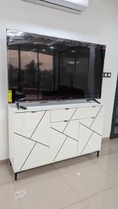 a large white dresser with a tv on top of it at Villa Victoria Résidence in Lomé