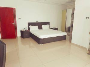 a bedroom with a bed and a red cabinet at Villa Victoria Résidence in Lomé +15 photos