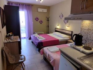 een hotelkamer met 2 bedden en een keuken bij Villa Anastasia in Limenas
