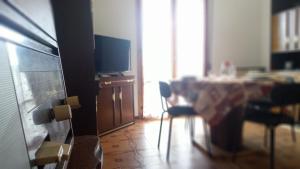 a dining room with a table and a television at Casa Luciano Bellaria Centro in Bellaria-Igea Marina