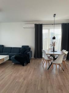 Klimatizovaný Apartmánový dom, s vírivkou, 1B في سينيتش: غرفة معيشة مع طاولة وأريكة زرقاء