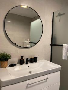ein Badezimmer mit einem weißen Waschbecken und einem Spiegel in der Unterkunft Klimatizovaný Apartmánový dom, s vírivkou, 1B in Senec