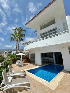 a villa with a swimming pool and a house at Luxury Villa Taoro private heated pool Free Car Except Christmas in Adeje