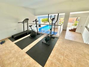 a gym with exercise bikes and a swimming pool at Luxury Villa Taoro private heated pool Free Car Except Christmas in Adeje