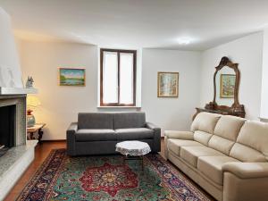 uma sala de estar com um sofá e uma cadeira em Gorgeous large apartment in mountains em Ballabio