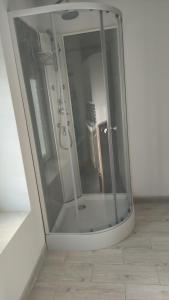 a glass shower in a room with a tile floor at maison de campagne rénovée in Duras