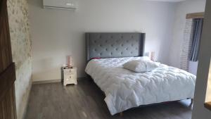a bedroom with a bed with a pillow on it at maison de campagne rénovée avec piscine in Duras