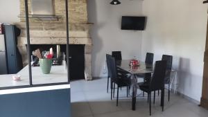a dining room with a table and black chairs at maison de campagne rénovée in Duras