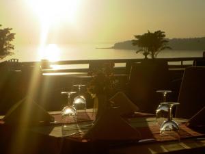 a table with glasses and flowers on it with the sunset at Silivri Park Hotel in Silivri