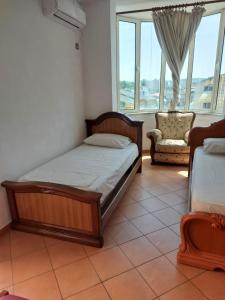 a bedroom with a bed and a chair and a window at Iliria Durres Apartments in Durrës +52 photos