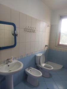 a bathroom with a sink and a toilet and a mirror at Iliria Durres Apartments in Durrës
