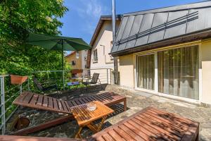 a patio with a table and chairs and an umbrella at Pensiunea Casa Bono - Cazare Brasov in Braşov