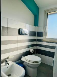 La salle de bains est pourvue de toilettes blanches et d'un lavabo. dans l'établissement Mansarde Marzamemi, à Marzamemi