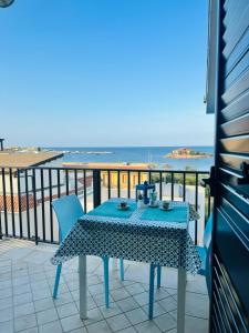 stół i krzesła na balkonie z widokiem na ocean w obiekcie Mansarde Marzamemi w mieście Marzamemi