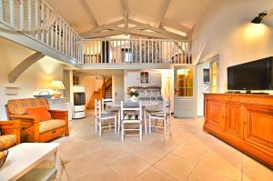 a large living room with a table and chairs at Le Fief des Roses in Les Mathes