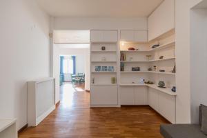 a living room with white shelves and a wooden floor at una bomboniera a Posillipo in Naples