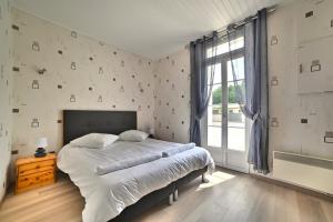 a bedroom with a large bed and a window at Le Fief des Roses in Les Mathes +24 photos