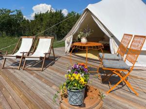 帕達斯特的住宿－Pädaste Aerga Sunrise Glamping，两把椅子、一张桌子和一个帐篷