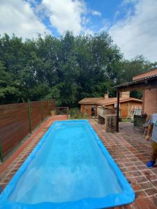a large blue swimming pool in a backyard at Cabañas Aromas Serranos in Alta Gracia