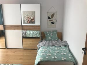 1 dormitorio con cama y espejo en Apartmán pod Lesom Kežmarok, en Kežmarok