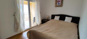 a bedroom with a large bed with a window at View Apartment in Krašići