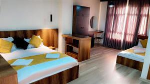 Cette chambre comprend deux lits et un bureau. dans l'établissement Nightview Erbil, à Erbil