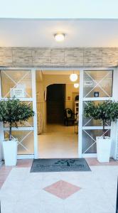 a room with two potted trees in a building at Dionisos Elia in Paralia Dionysiou