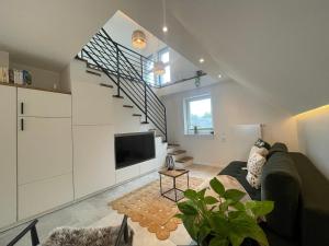 a living room with a couch and a tv at FeWo „Am alten Eifelhaus“ in Monschau