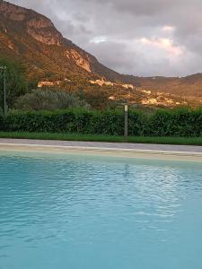 una piscina di acqua blu di fronte a una montagna di Case vacanza Cilentane a Giungano