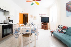 une cuisine et un salon avec une table et un canapé dans l'établissement Casa Sole, à Favignana