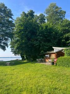 a cabin with tables and chairs in a grass field at Ferienwohnung vor den Toren Berlins in Heidesee