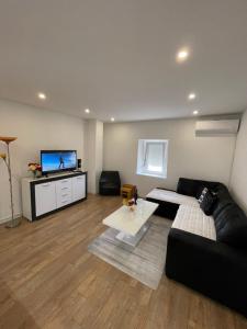 a living room with a couch and a flat screen tv at Apartman Dorotea in Trebinje