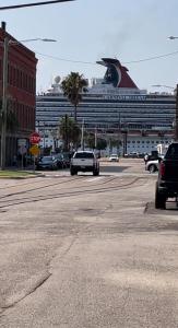 a car driving down a street with a cruise ship at A Gem on the Strand in Galveston