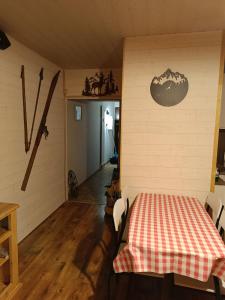 una habitación con una mesa con un mantel a cuadros en la pared en Appartement Paisible en Briançon