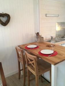 a wooden table with two plates and glasses on it at Studio centre village Ceillac in Ceillac