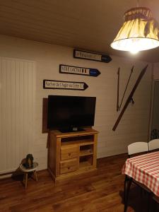 a living room with a television on a wooden cabinet at Appartement Paisible in Briançon