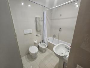 een witte badkamer met een toilet en een wastafel bij PCQ Apartments - Centro Città in Genua