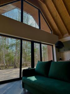 a living room with a green couch and windows at Siilihouse in Padise +20 photos